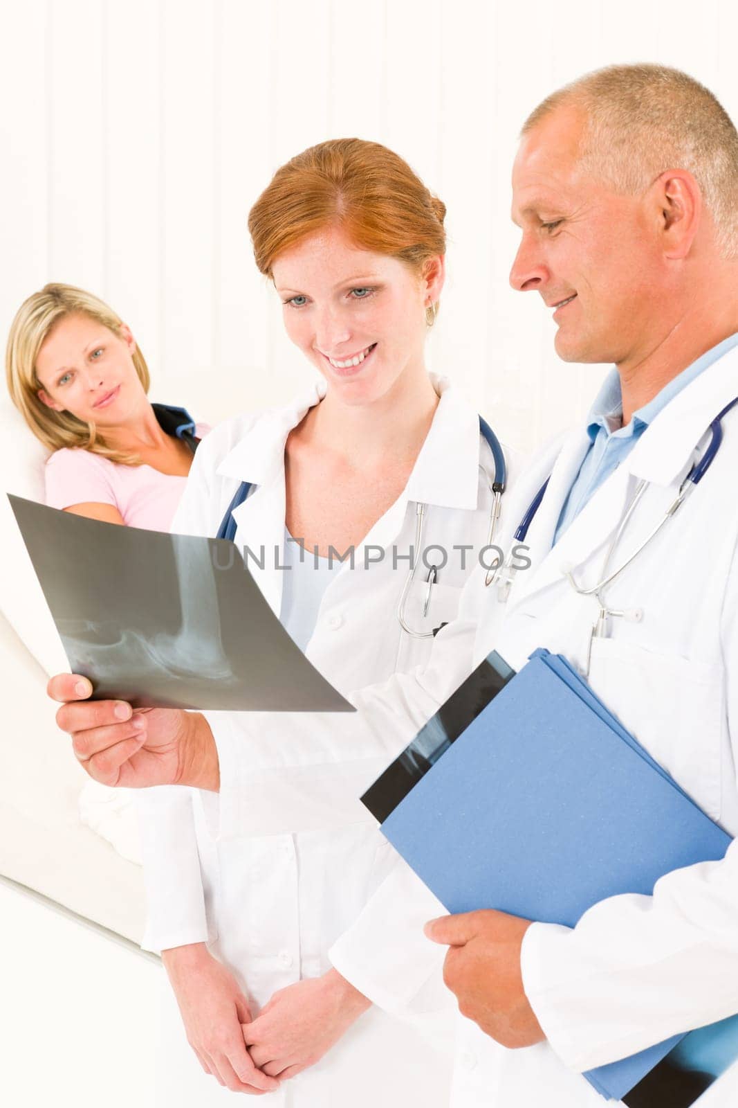 Medical doctors look at x-ray hospital patient in bed broken arm