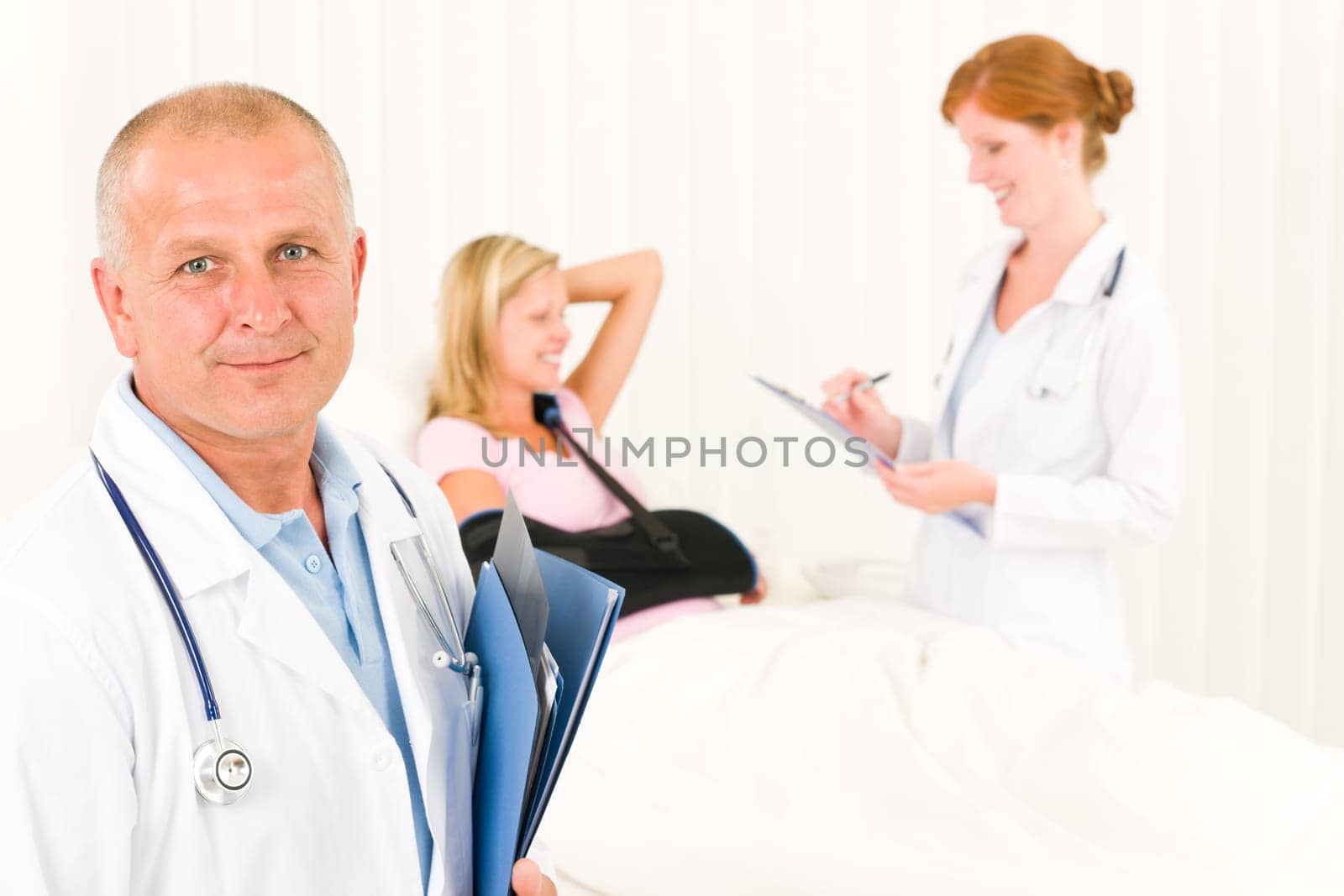 Two medical doctors professional with hospital patient lying in bed