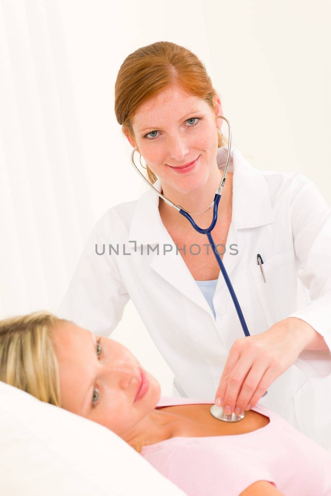 Medical professional doctor stethoscope examine woman patient lying in bed