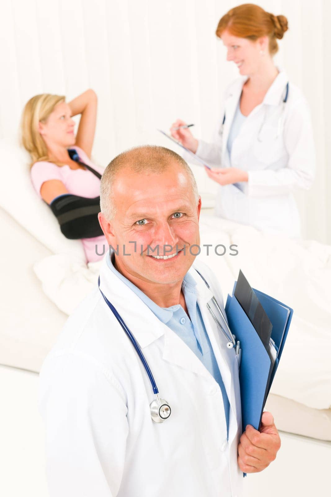Medical doctors professional with hospital patient broken arm lying in bed
