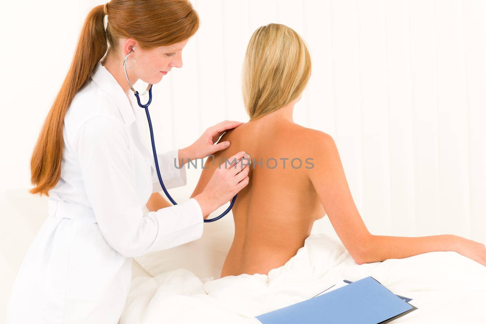 Medical professional doctor with stethoscope examine woman patient naked back