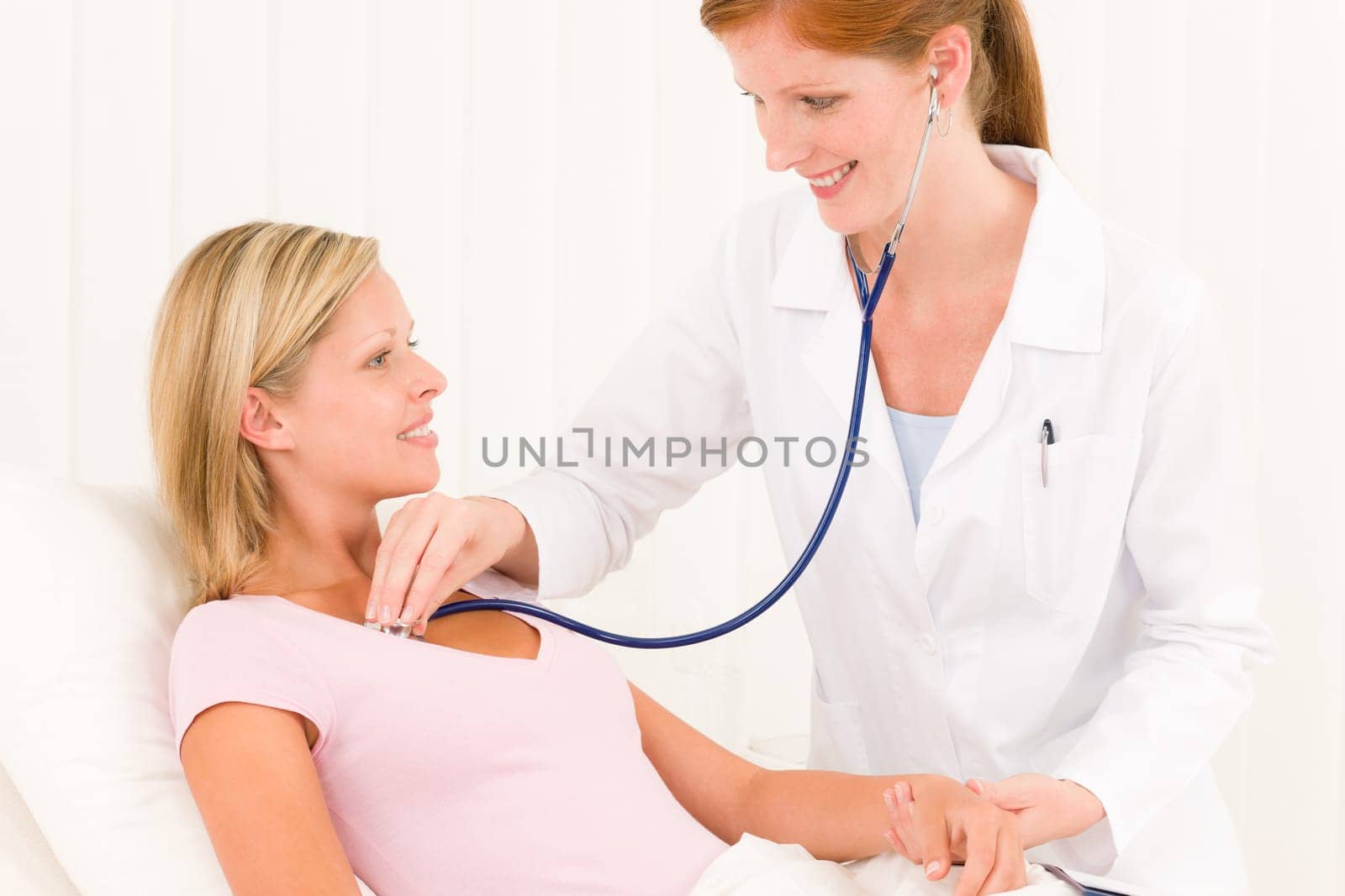 Medical professional doctor stethoscope examine woman patient lying in bed