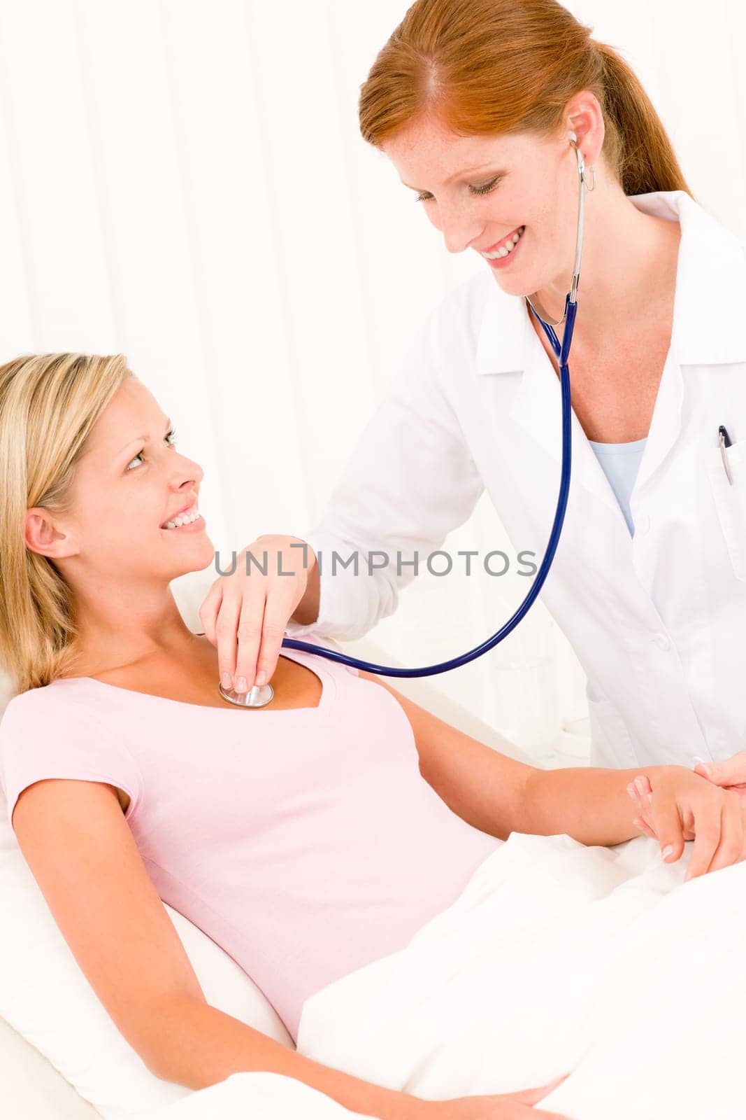 Medical professional doctor stethoscope examine woman patient lying in bed