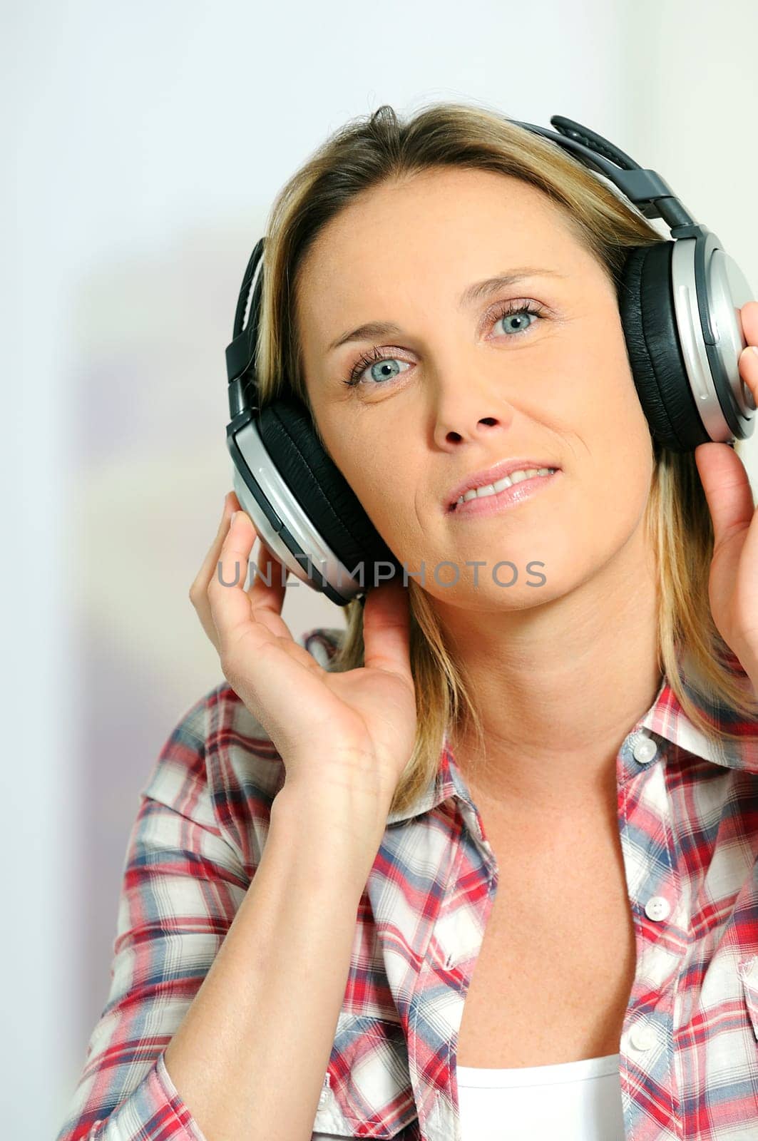 blond woman relaxing at home, listening music