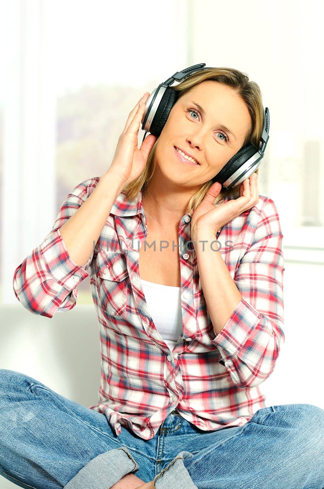 blond woman relaxing at home, listening music