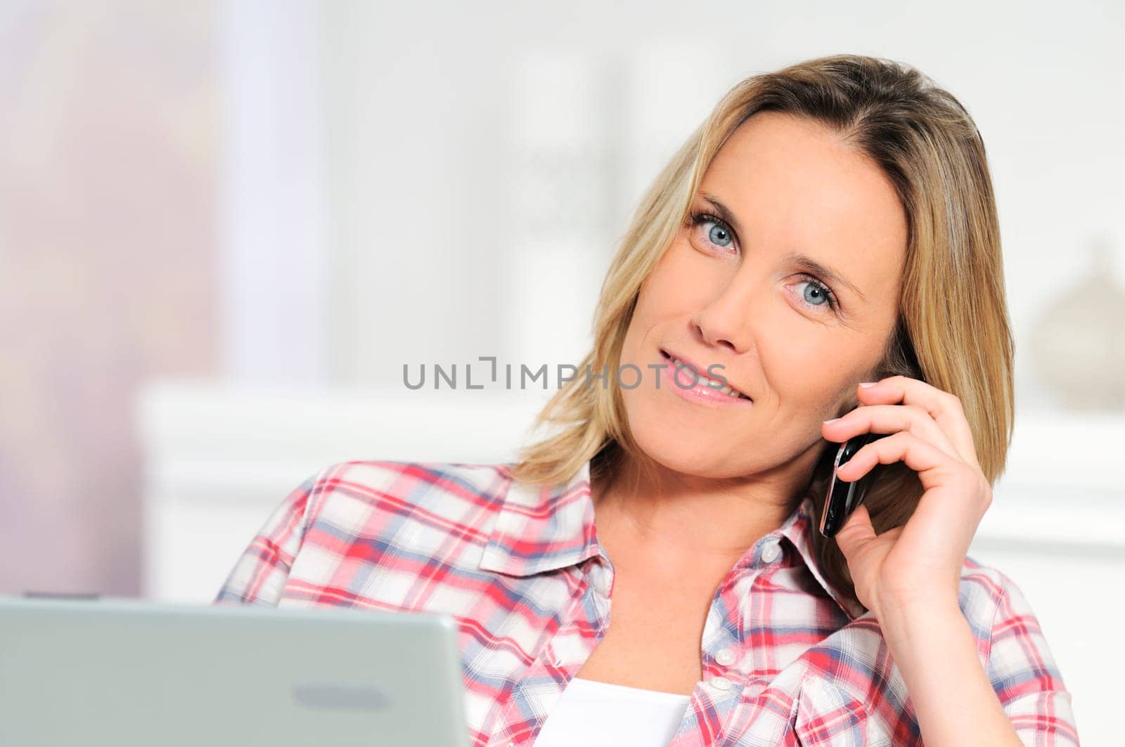 Blond beautiful woman doing talking on the phone at home