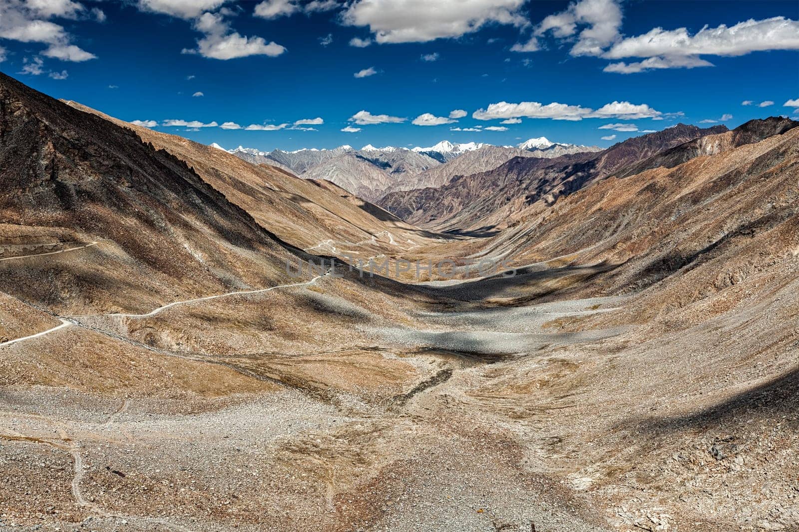 View of Karakoram range and road in valley from Kardung La - the highest motorable pass in the world (5602 m) in Himalayas. Ladakh, India