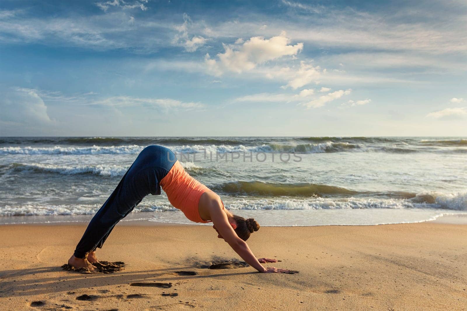Woman doing yoga Surya Namaskar oudoors at tropical beach by dimol