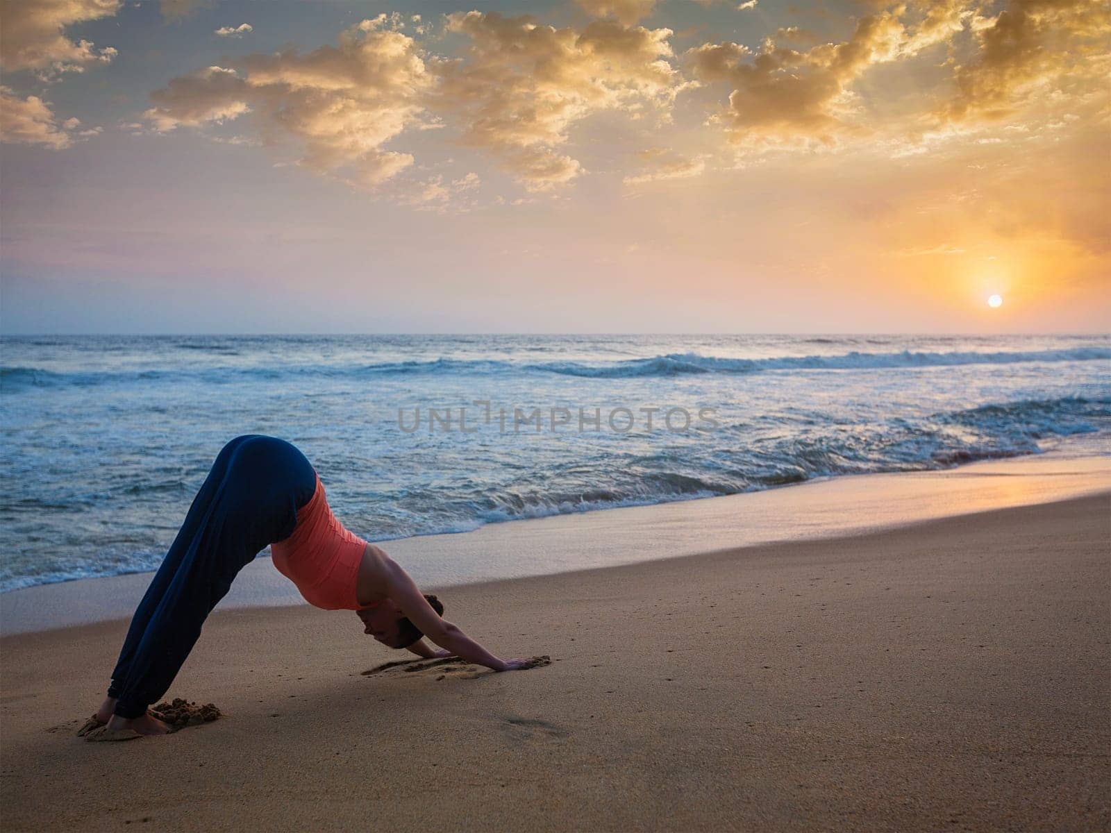 Woman doing yoga Surya Namaskar oudoors at tropical beach by dimol