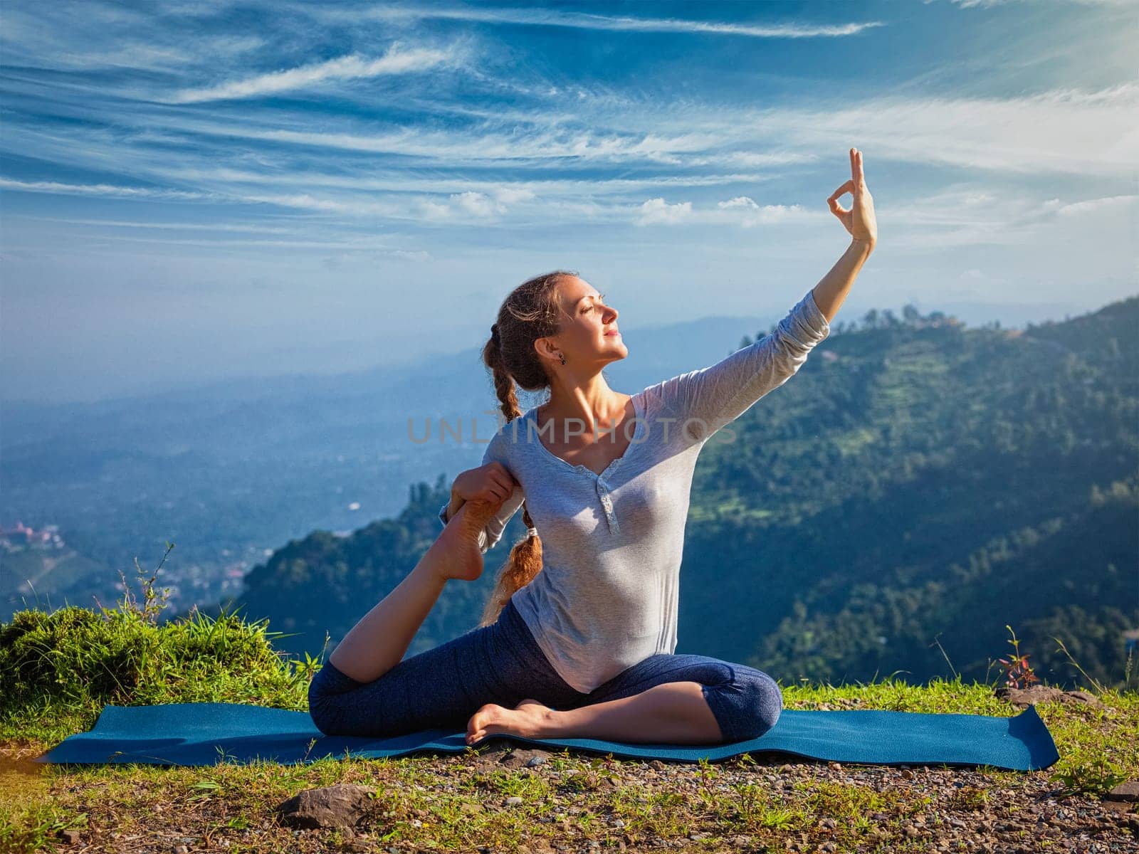 Sorty fit woman doing yoga asana outdoors in mountains by dimol