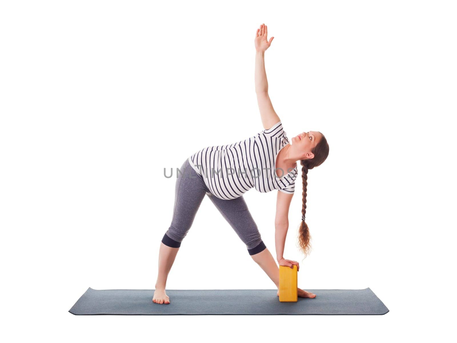 Pregnancy yoga exercise - pregnant woman doing asana Utthita trikonasana - extended triangle pose with block isolated on white background