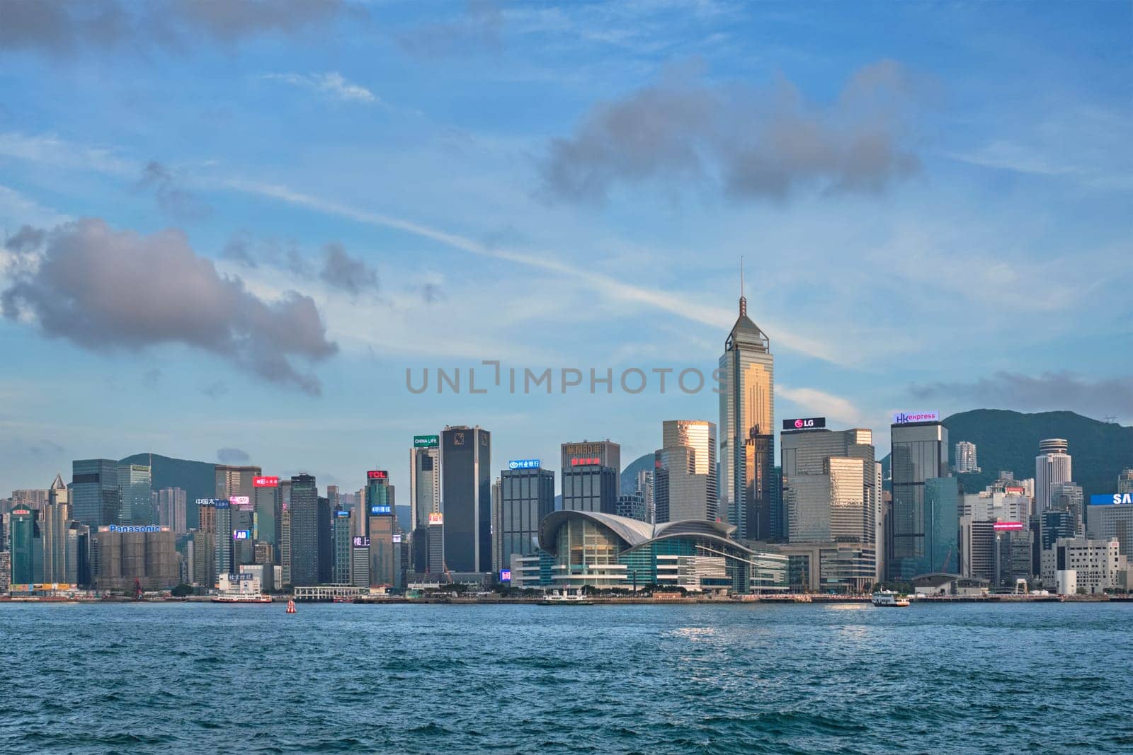 HONG KONG, CHINA - MAY 1, 2018: Hong Kong skyline cityscape downtown skyscrapers over Victoria Harbour in the day time with clouds. Hong Kong, China. Horizontal camera panning