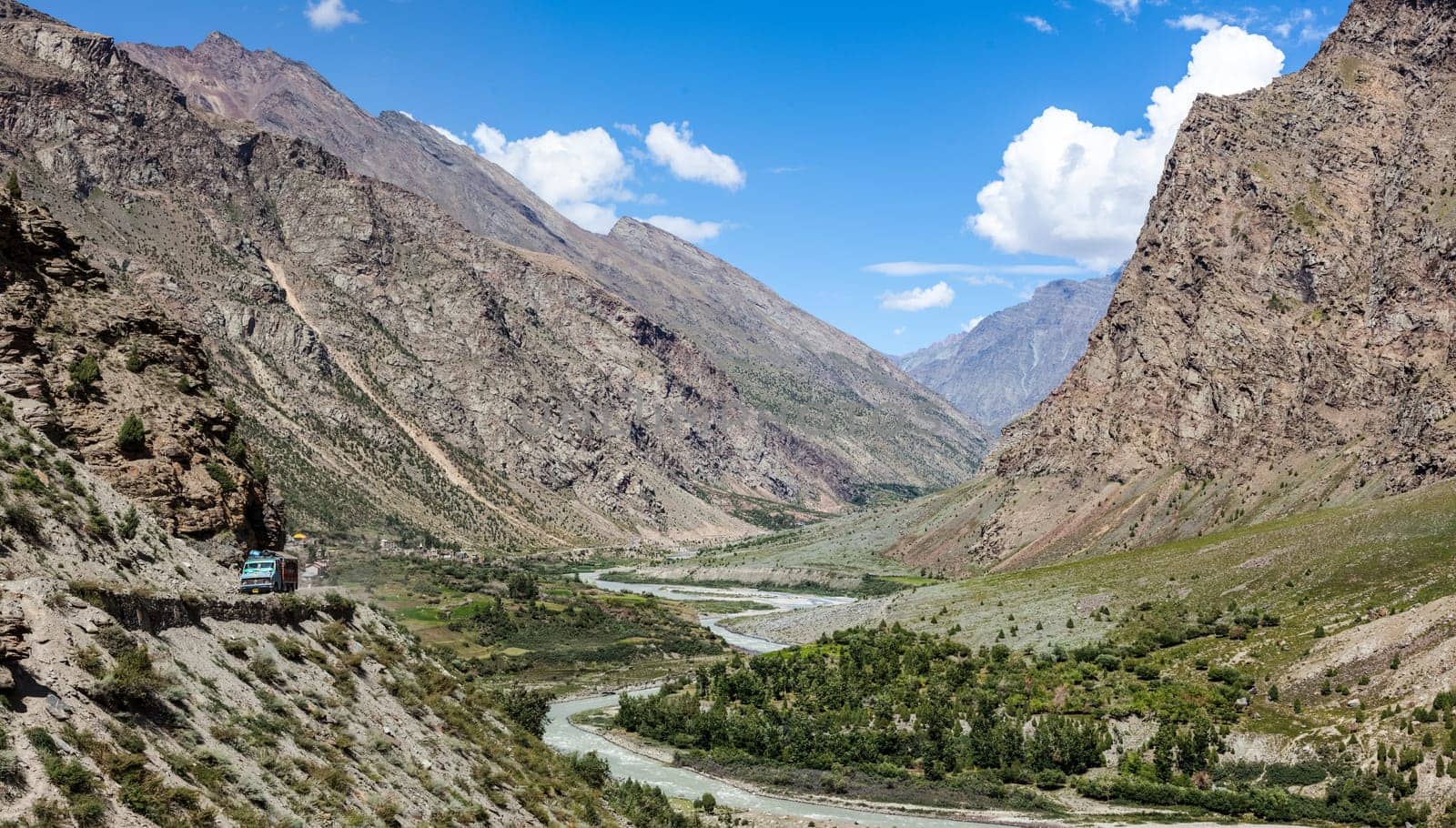 Manali-Leh road in Indian Himalayas with lorry and Chandra river in Lahaul valley. Himachal Pradesh, India