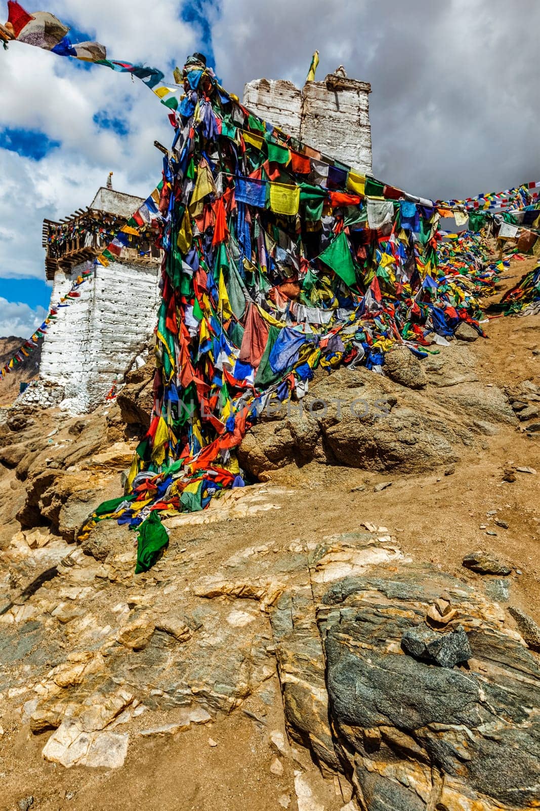 Ruins of Victory Fort Tsemo on the cliff of Namgyal hill and colorful Buddhist prayer flags with Buddhism mantra written on them. Leh, Ladakh, Jammu and Kashmir, India
