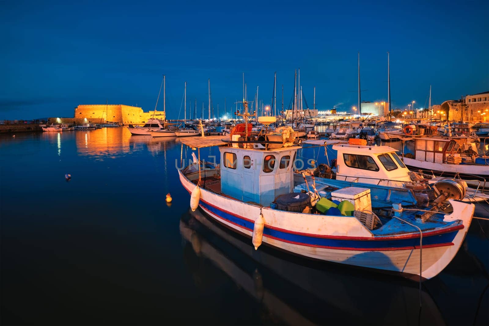 Venetian Fort Venetian fortress of Koules Castello a Mare castle in Heraklion and moored Greek fishing boats in port, Crete Island, Greece in the evening