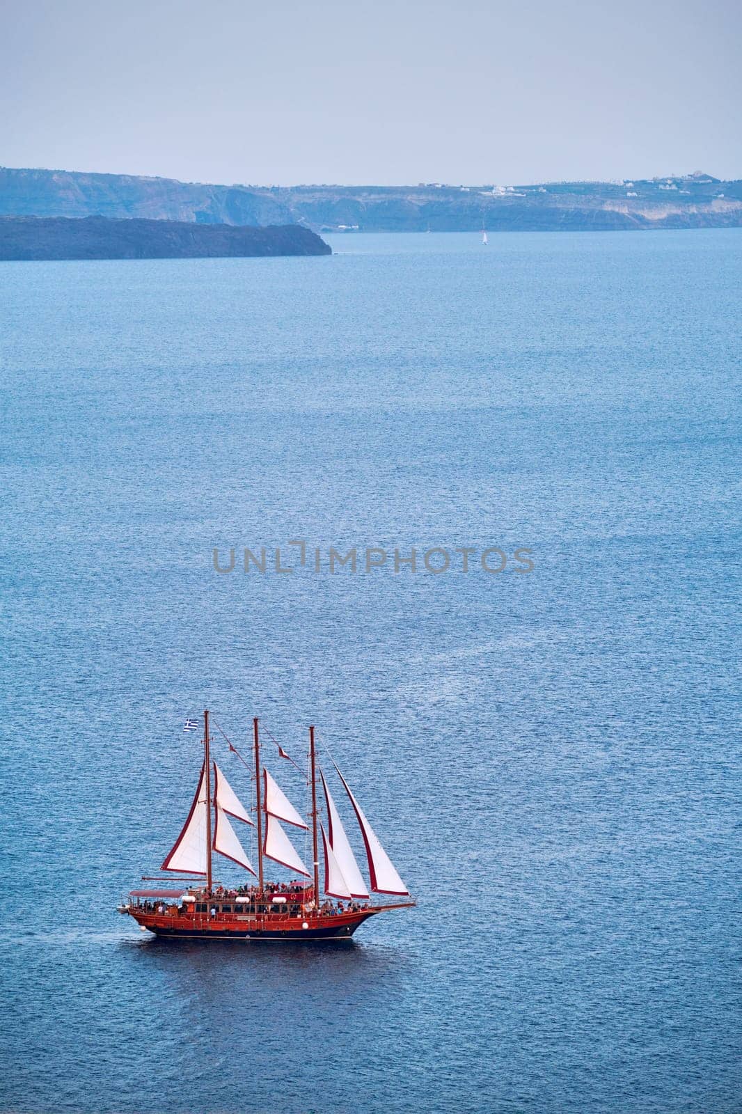Schooner vessel ship boat in Aegean sea near Santorini island with tourists going to sunset viewpoint by dimol