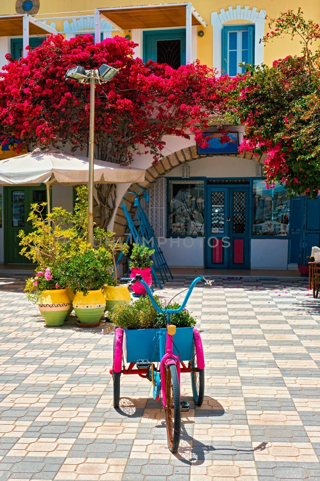 Picturesque street with colorful houses and blooming bougainvillea flowers in Adamantas town on Milos island in Greece