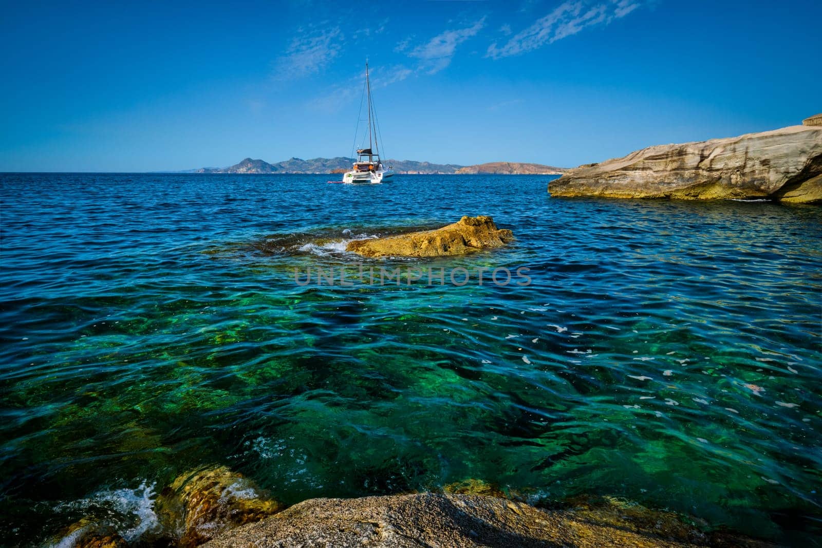 Yacht boat in Aegean sea at white rocks of Sarakiniko Beach, Milos island , Greece