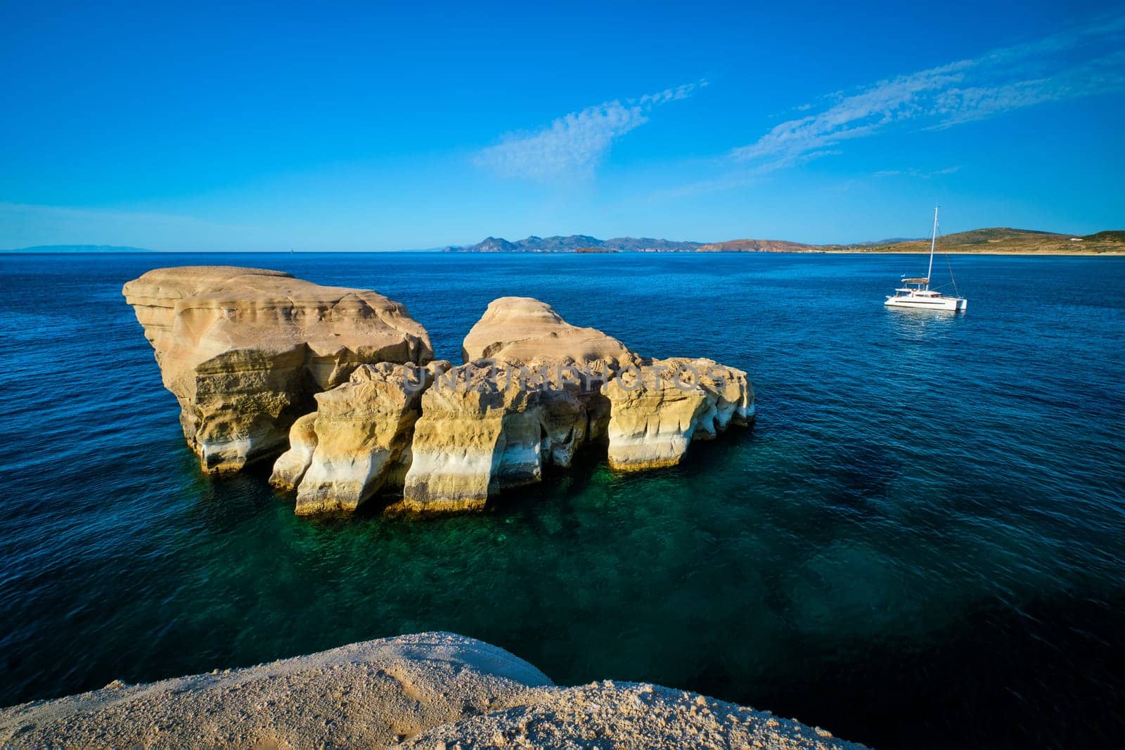 White rocks of famous tourist attraction of Milos island Sarakiniko beach and yacht boat at Sarakiniko Beach, Milos island , Greece