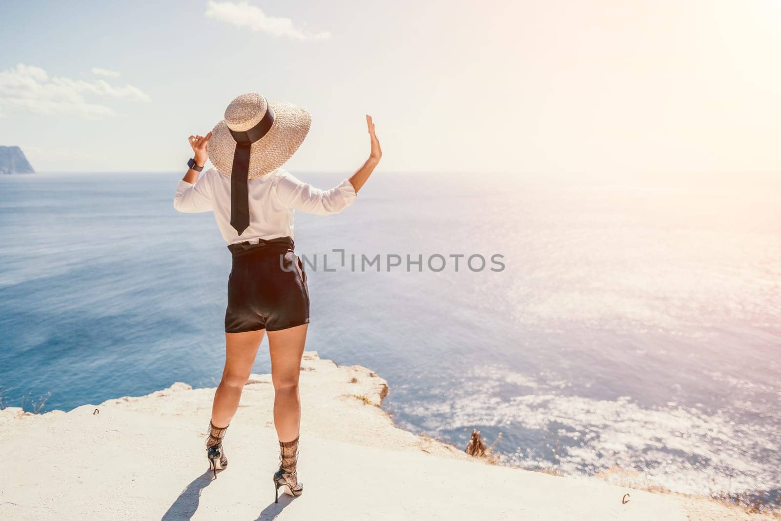 Woman sea hat. Business woman in yellow hat freelancer working over blue sea beach. Girl relieves stress from work. Freelance, digital nomad, travel and holidays concept by panophotograph