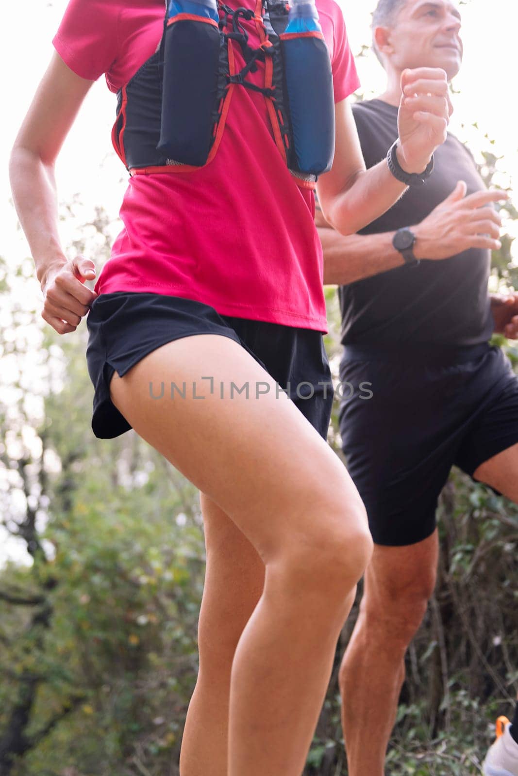 sporty couple running in the forest, concept of sport in nature and healthy lifestyle