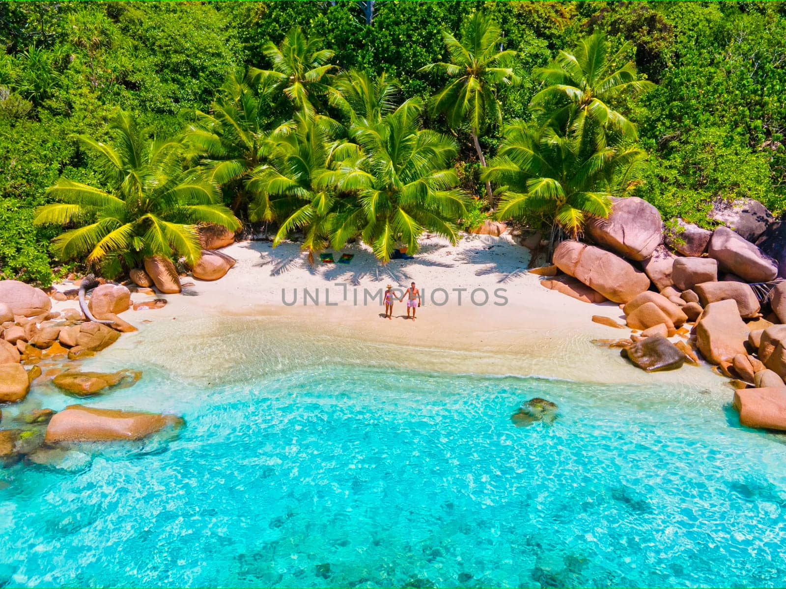 Anse Lazio Praslin Seychelles, a young couple of men and women on a tropical beach during a luxury vacation in Seychelles. Tropical beach Anse Lazio Praslin Seychelles