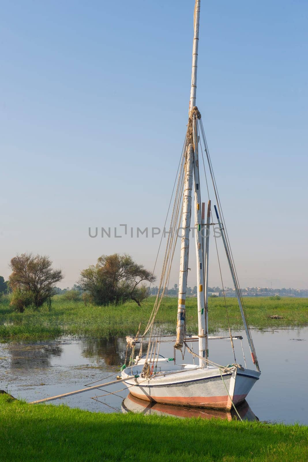 Wooden felluca sailing boat moored on river bank by paulvinten