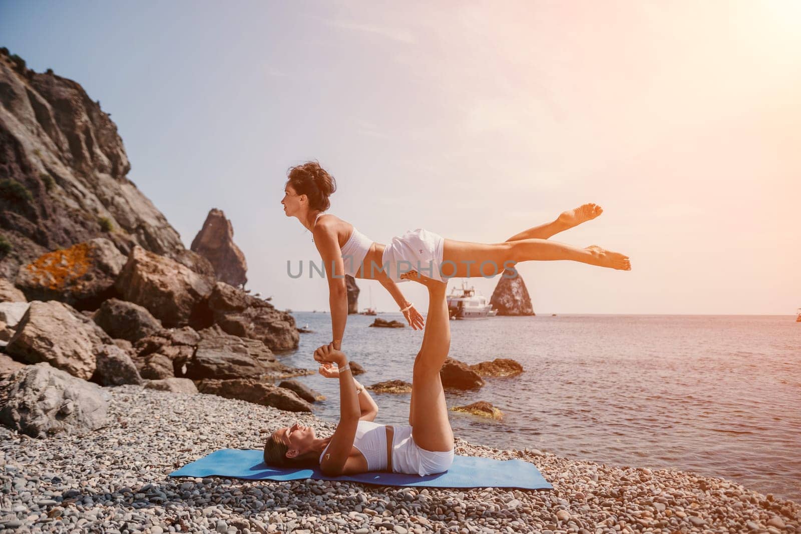 Woman sea yoga. Back view of free calm happy satisfied woman with long hair standing on top rock with yoga position against of sky by the sea. Healthy lifestyle outdoors in nature, fitness concept.