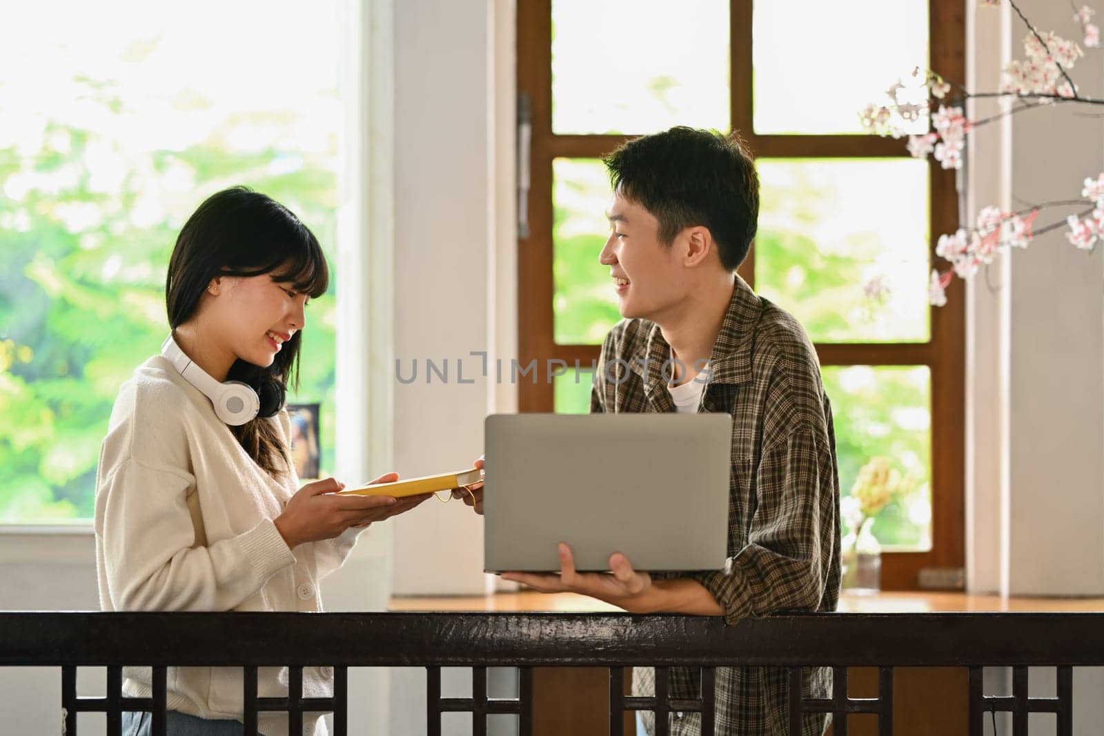 University students using laptop for researching online, collaborating on a project in campus.