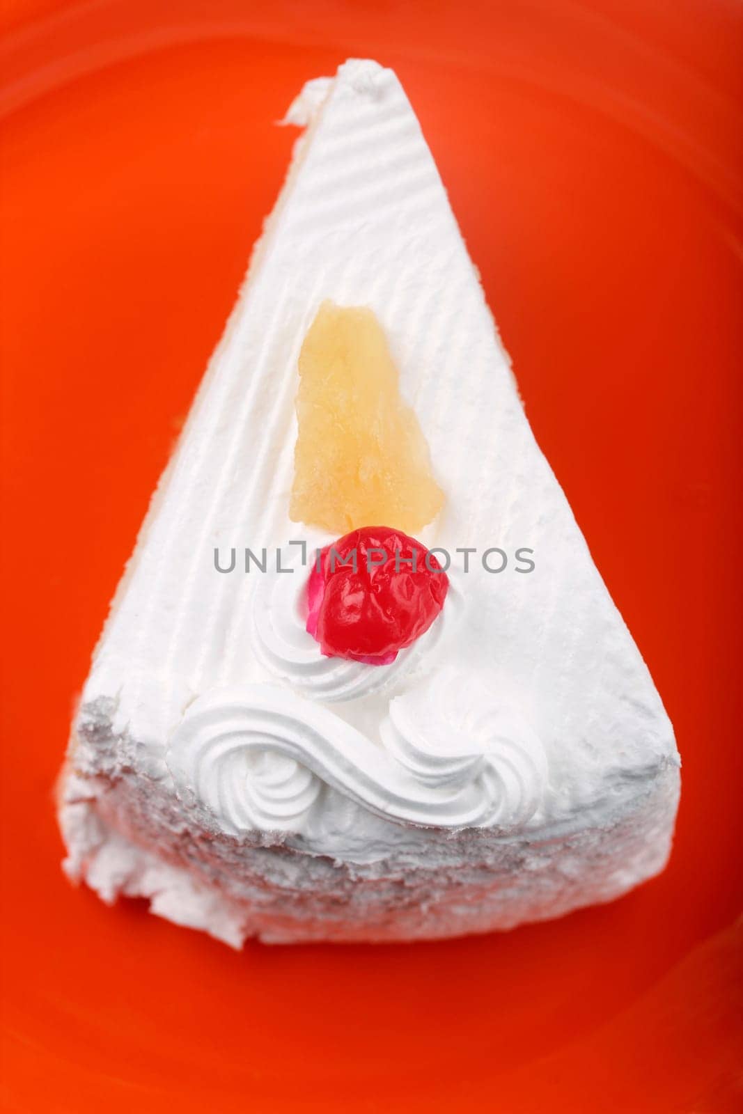 Pastry on a plate with cream and cherry
