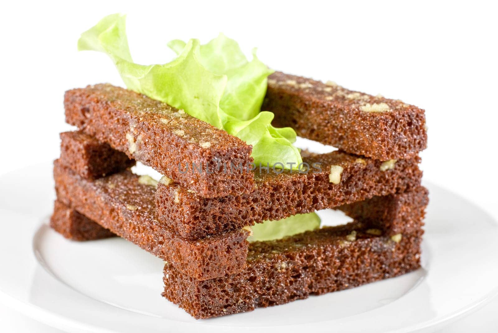 toasted bread with garlic at lettuce leaf on white