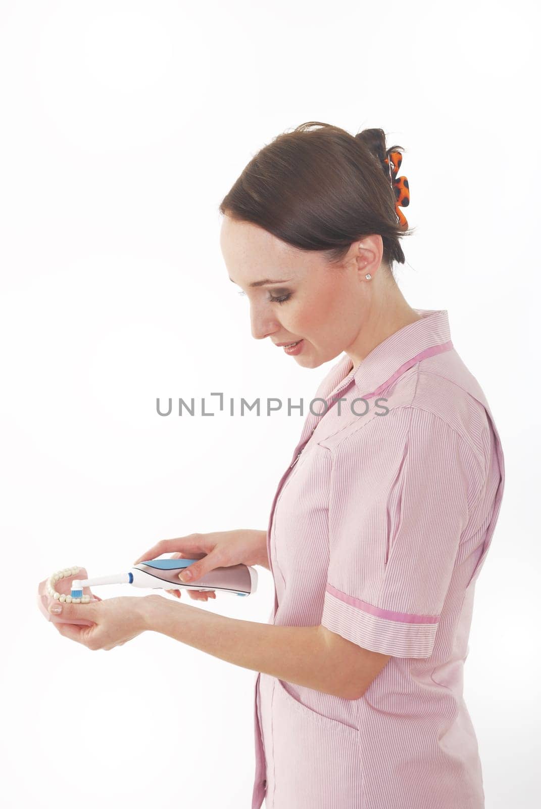 dental hygenist cleaning dentures with electric tootbrush