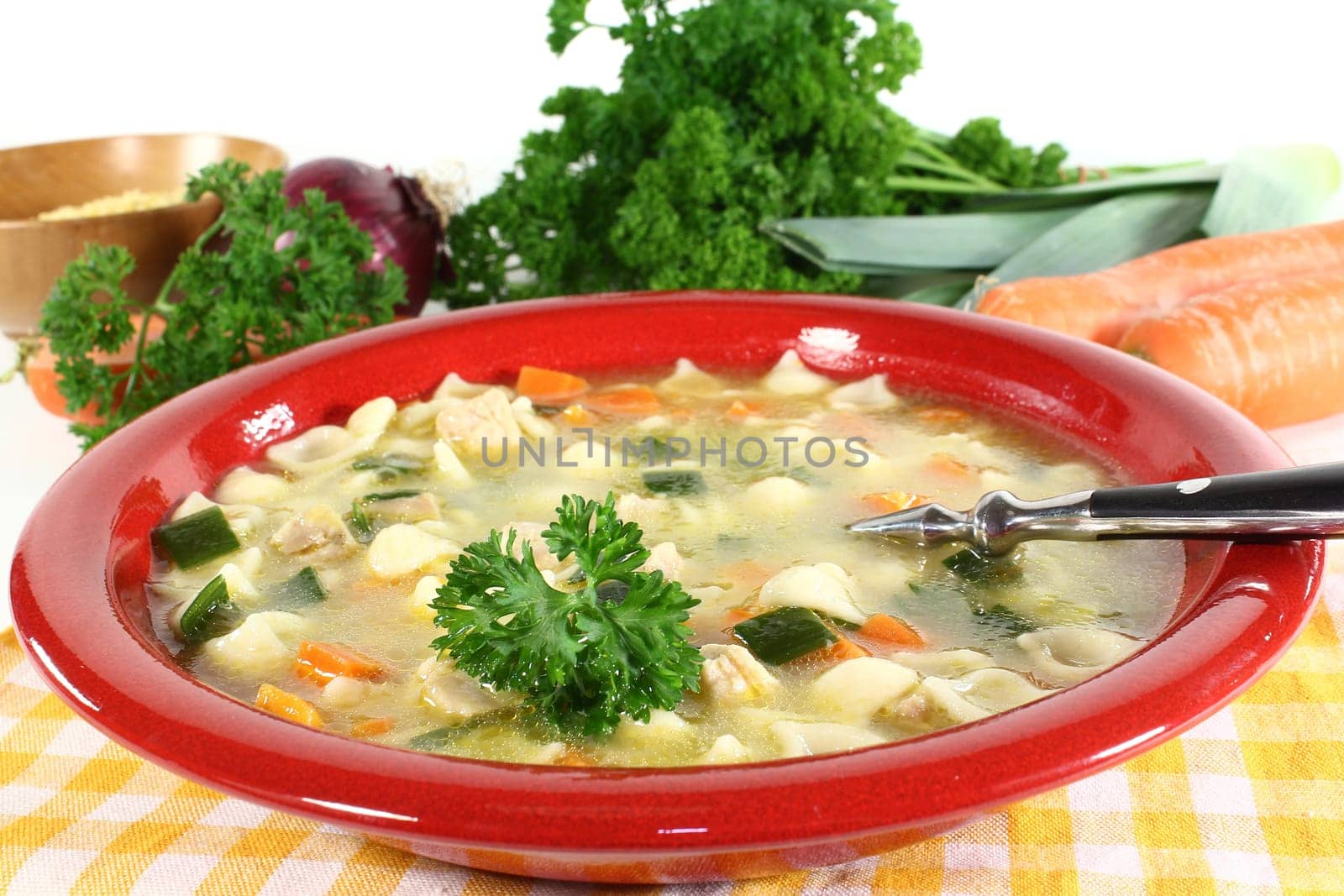 a bowl of chicken soup with fresh vegetables