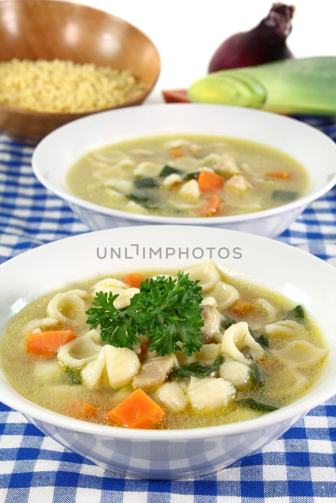 a bowl of chicken soup with fresh vegetables