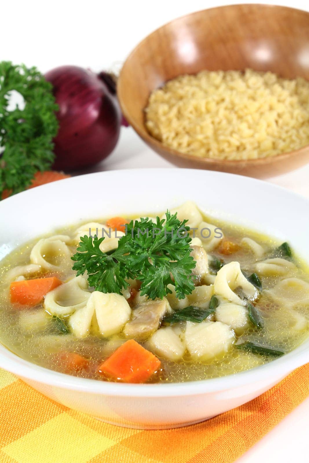 a bowl of chicken soup with fresh vegetables