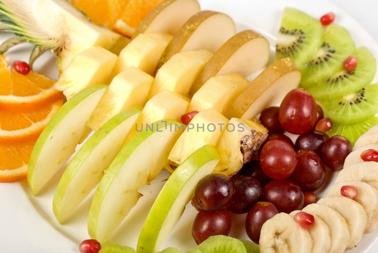 Fruit assortment closeup at plate on a white background