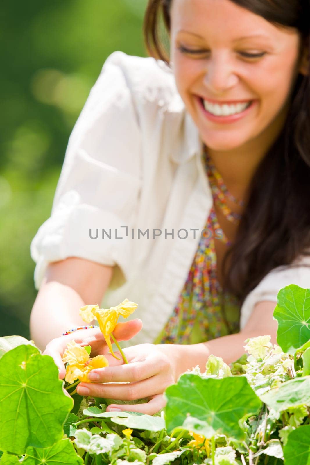 Summer garden beautiful young woman smiling care flowers