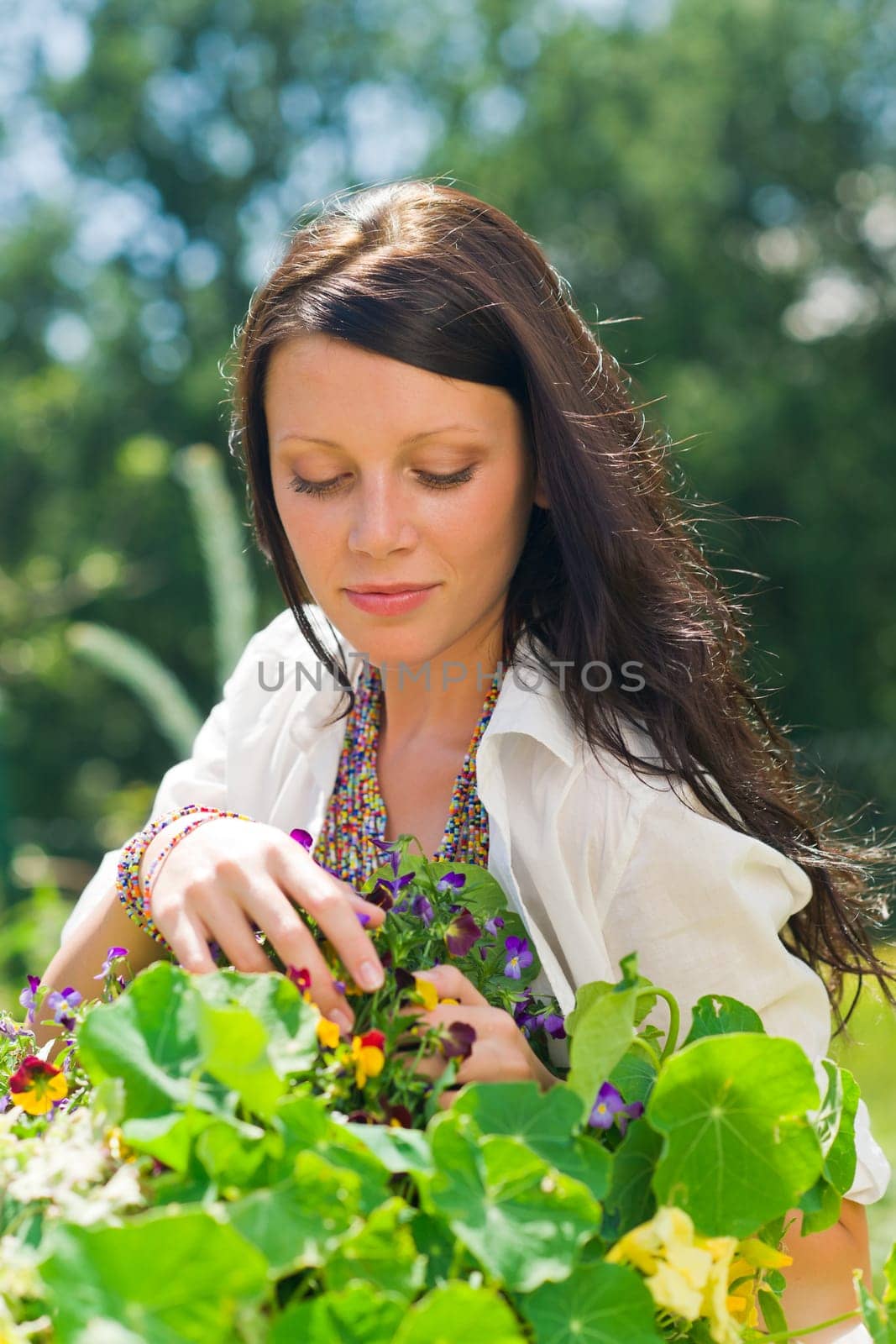 Summer garden beautiful young woman care colorful flowers