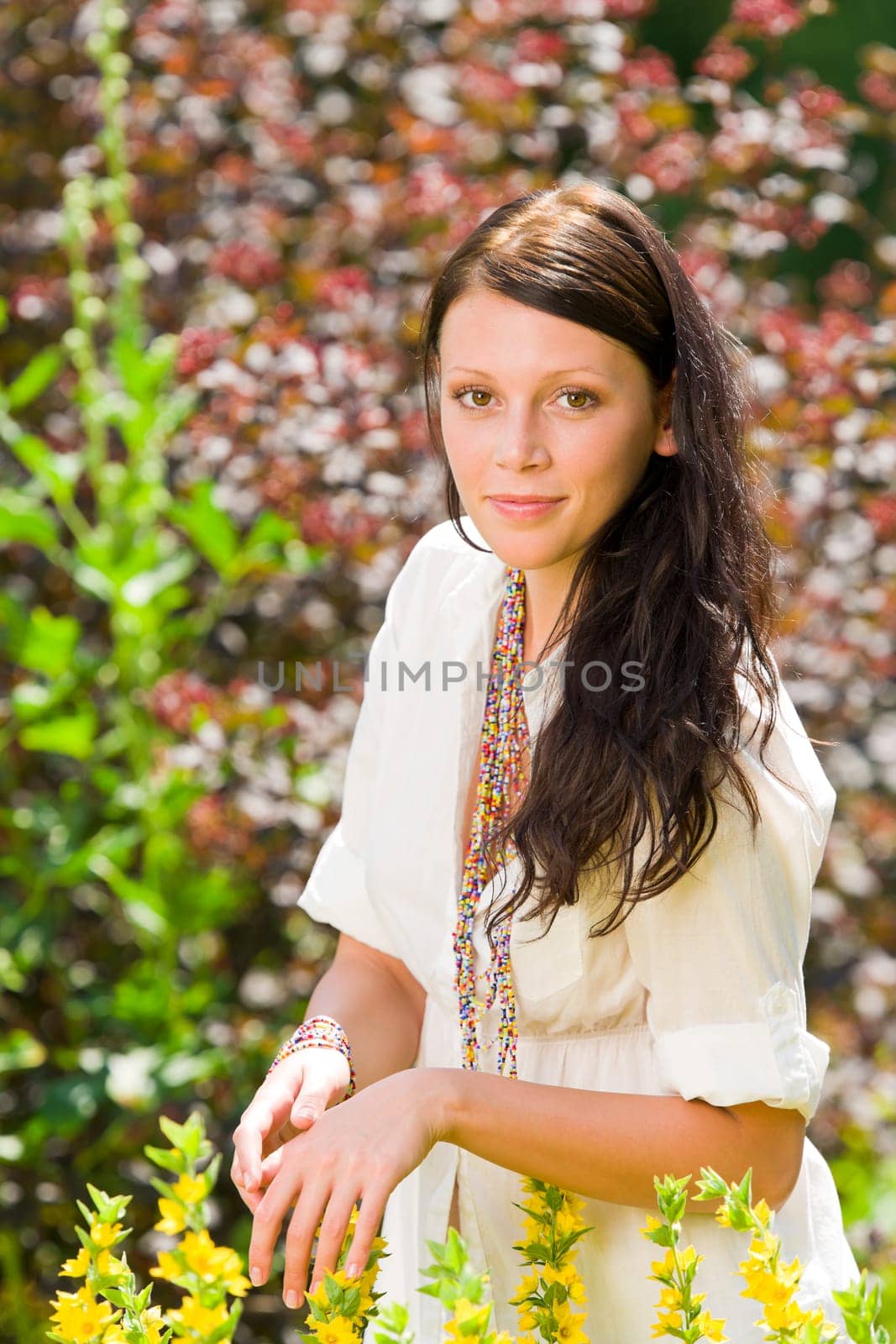 Beautiful young woman sunny garden care yellow flower portrait