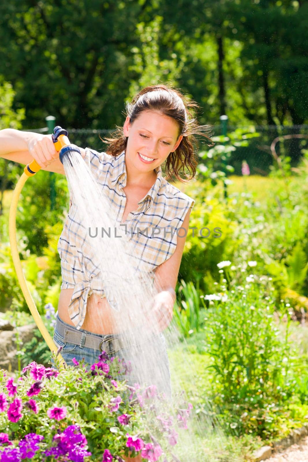 Summer garden smiling woman watering hose flower sunny day