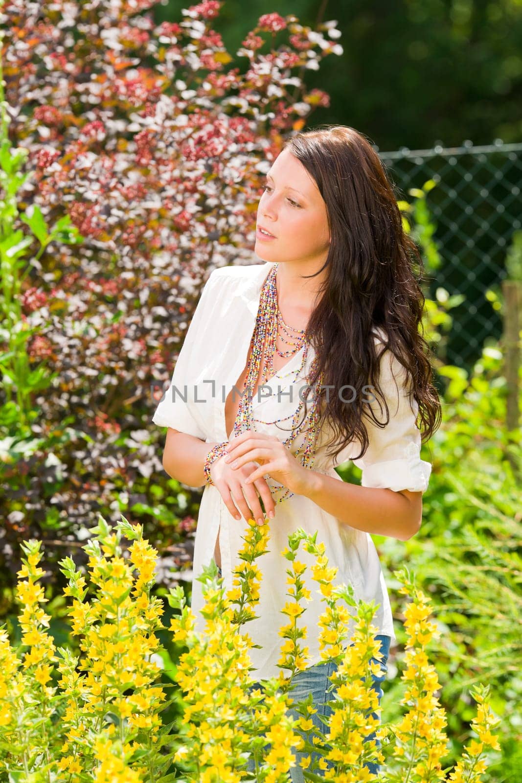 Beautiful young happy woman sunny yellow garden flower portrait