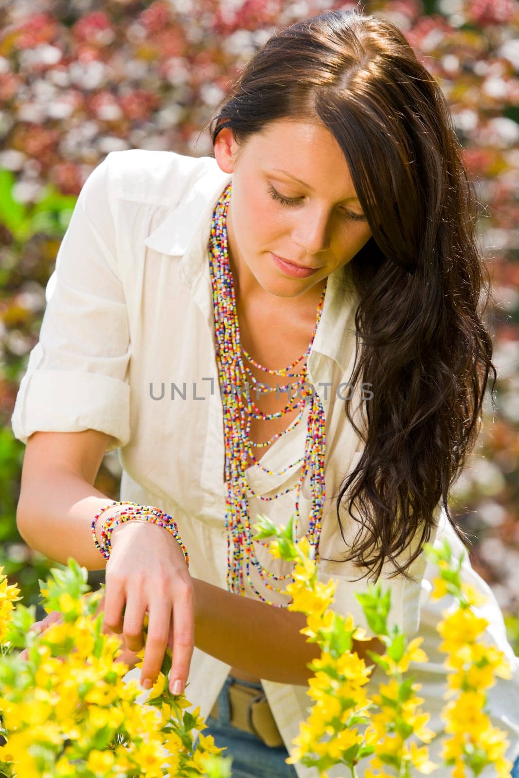Beautiful young woman sunny garden care yellow flower portrait