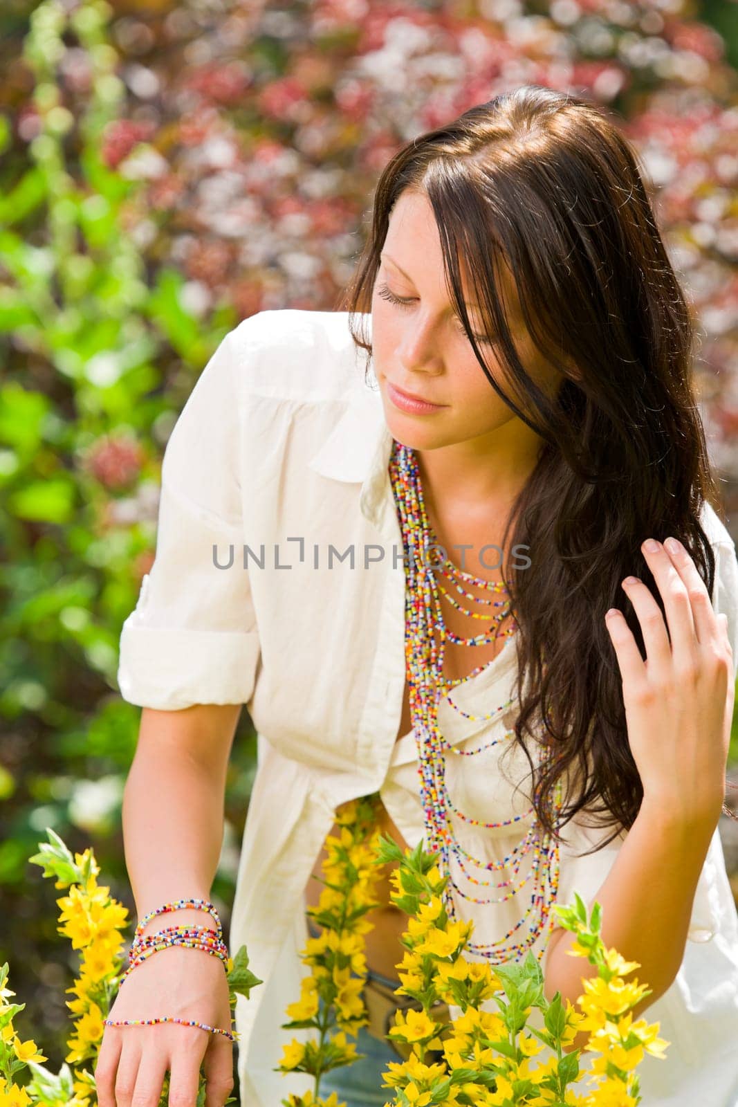 Beautiful young woman sunny garden care yellow flower portrait