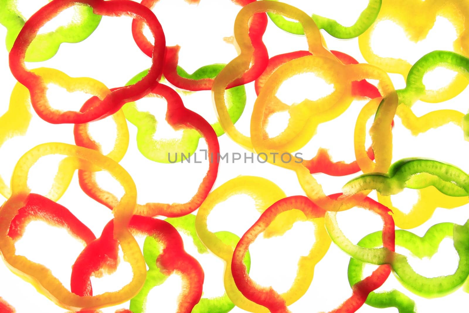 Slices of different colored sweet peppers isolated against white background
