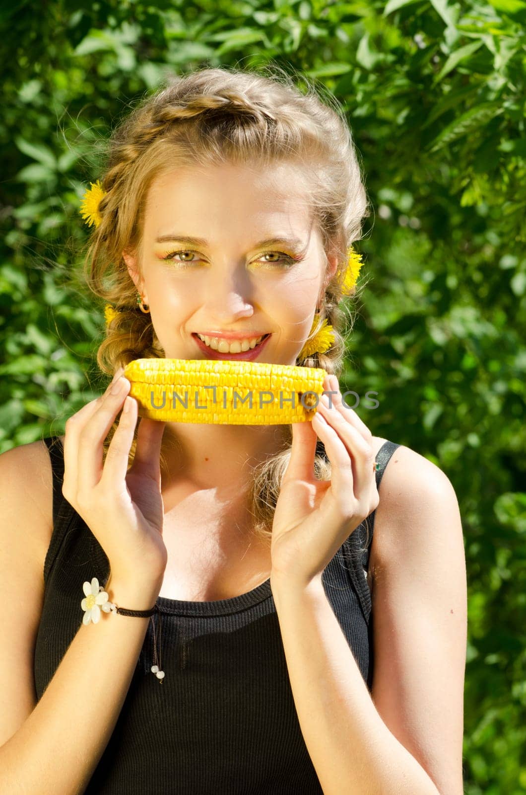Close-up outdoor portrait of young beauty woman eating corn-cob