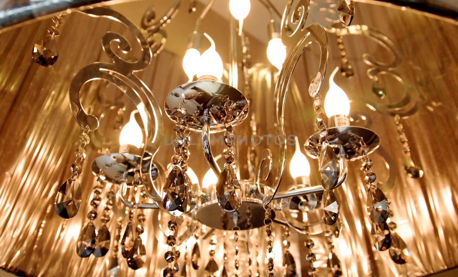 landscape close up off lampshade with candle flame bulds, mirrored detailing and dangling prisms, crop space
