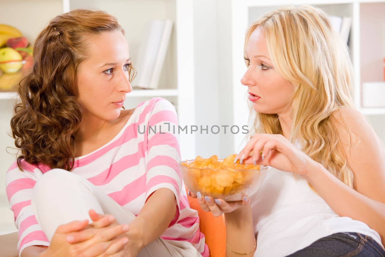 two women friends on sofa talking
