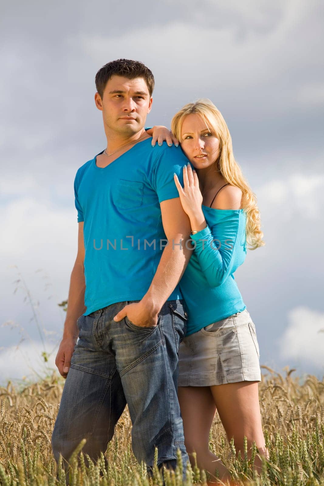young couple standing in wheat field