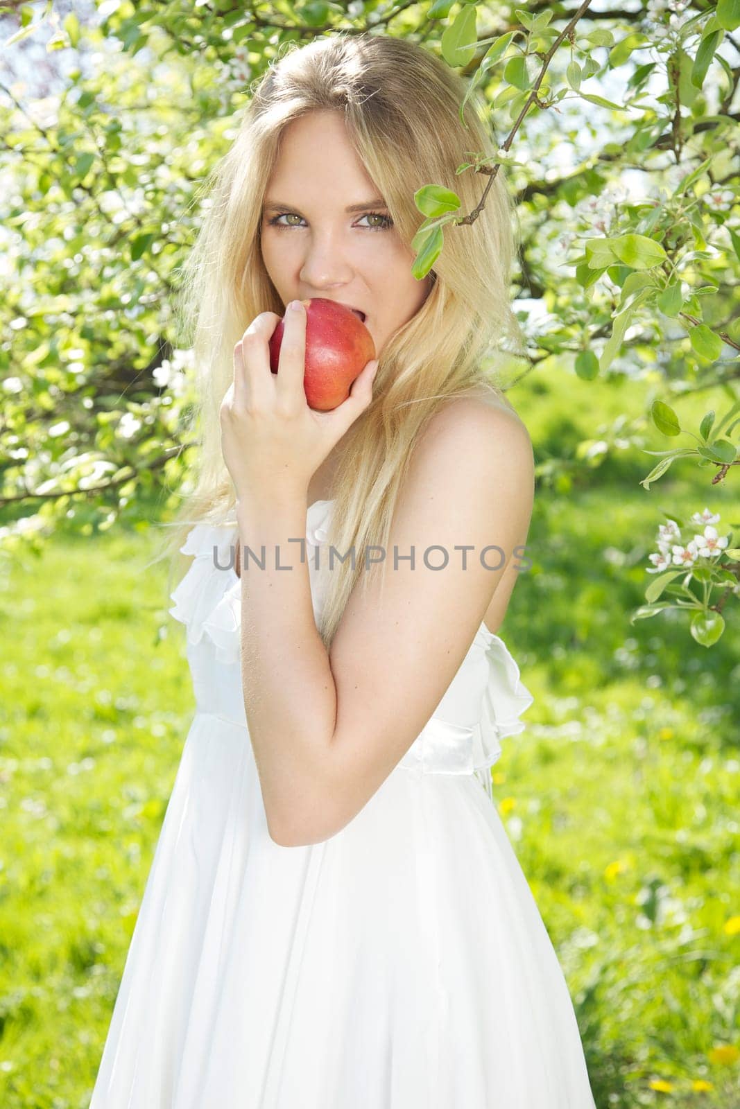Young woman in spring eating apple