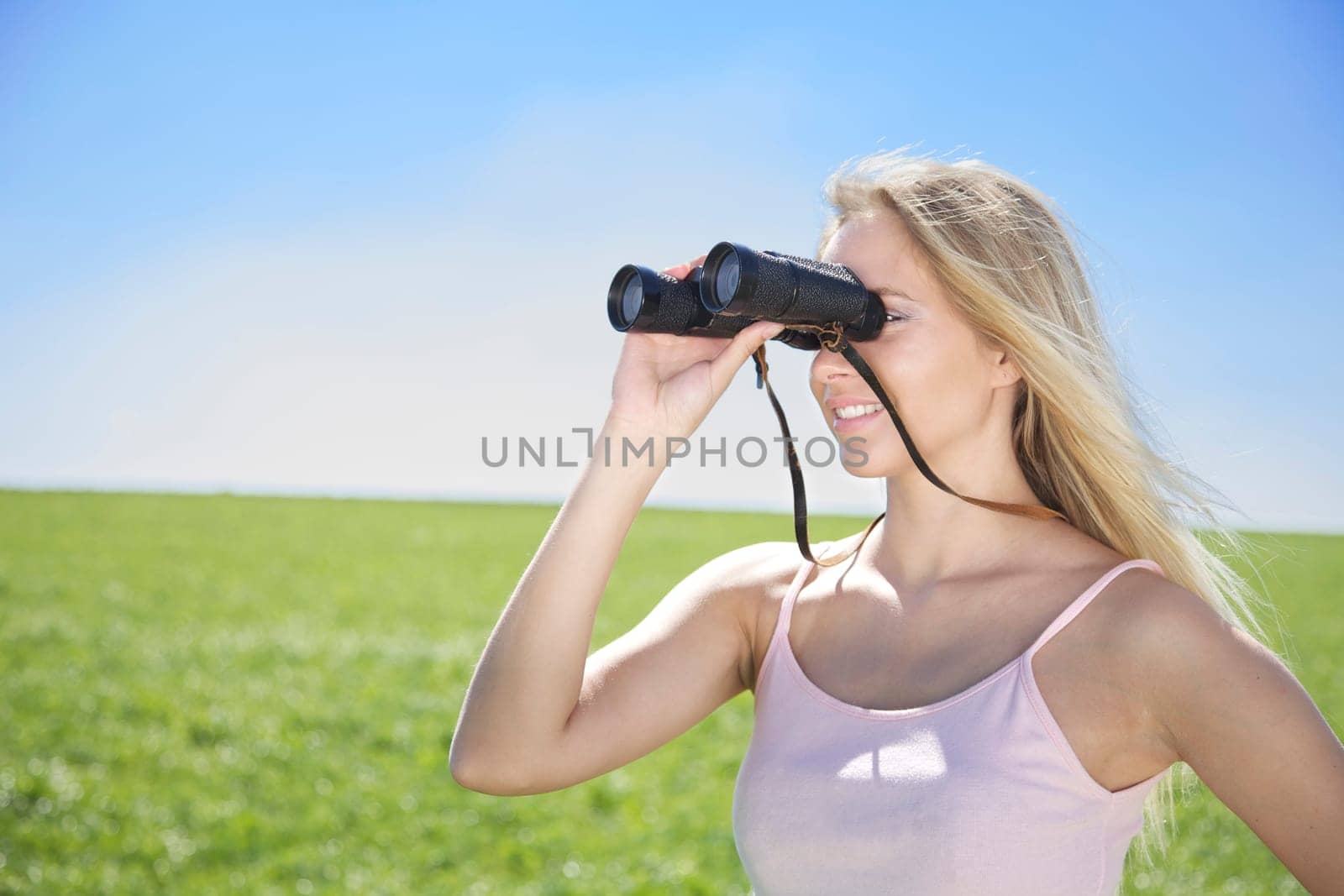 Young woman in spring or summer with binoculars
